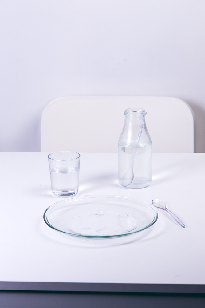 ﻿Plate, silverware, and glassware sitting on white table